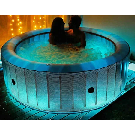 Mavi ışıklı şişme jakuzi içinde oturan çift, arka planda sıcak sarı dekoratif ışıklar