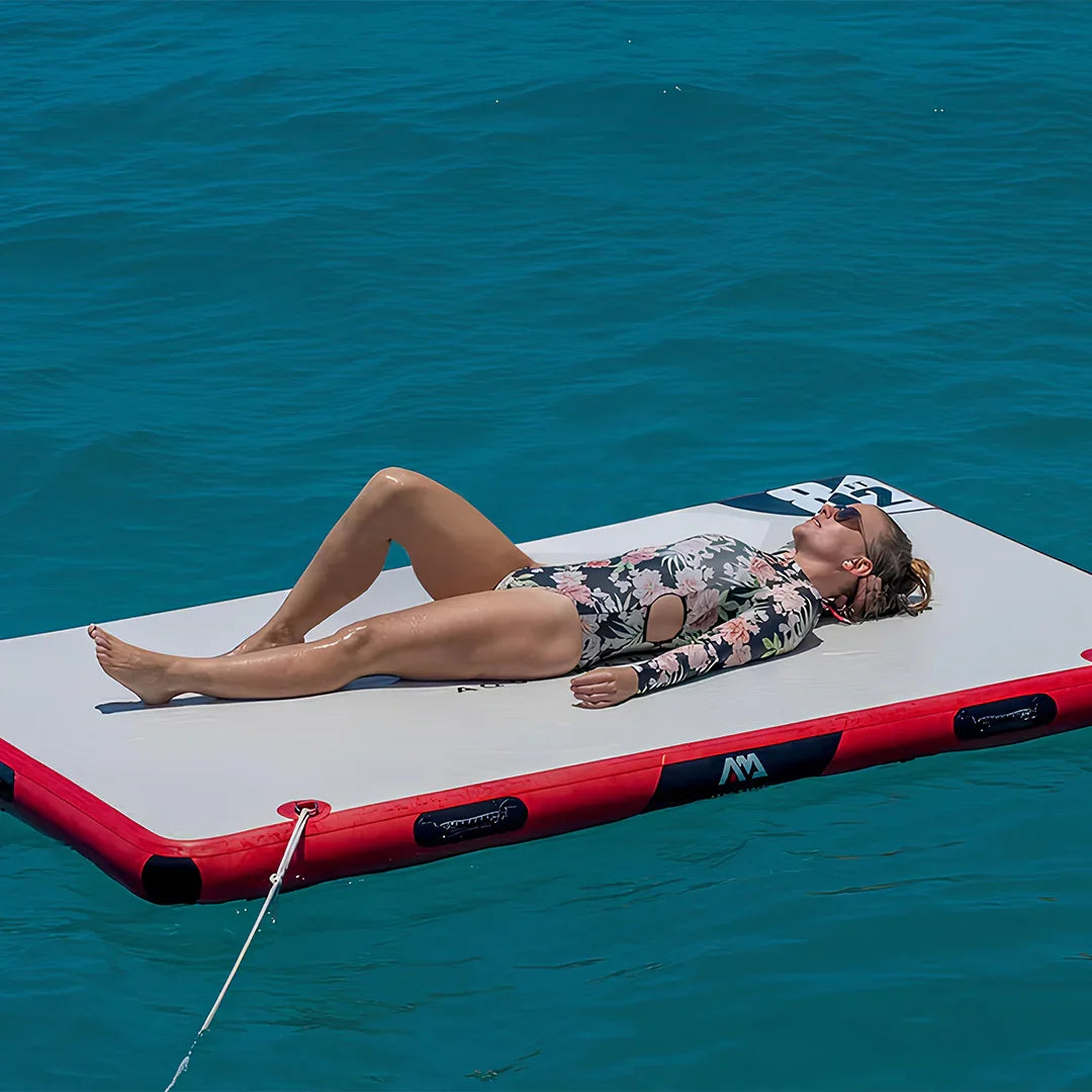 Çiçek desenli mayo giyen kadın, mavi denizde şişme yüzer platformda güneşleniyor