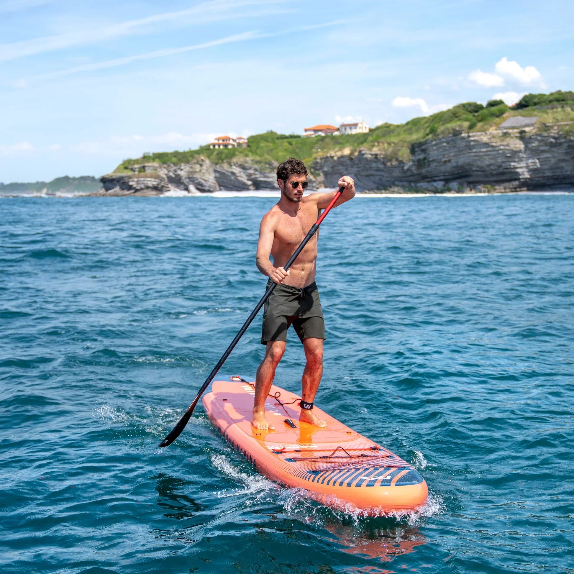 Denizde turuncu Aqua Marina Monster ISUP şişme stand up paddle tahtasında kürek çeken adam