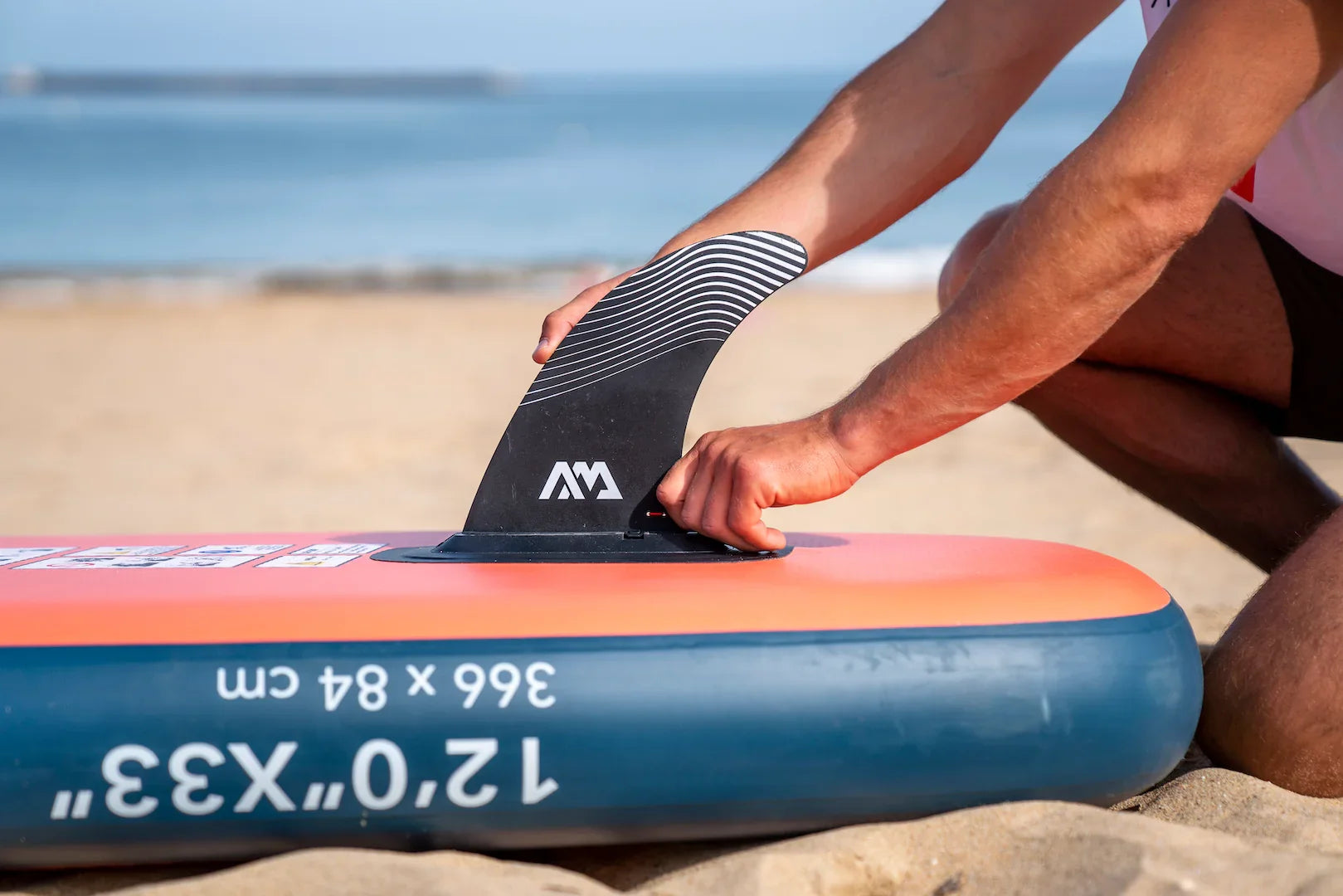 Kumda Aqua Marina Monster şişme stand up paddleboard yüzgecini takan kişi