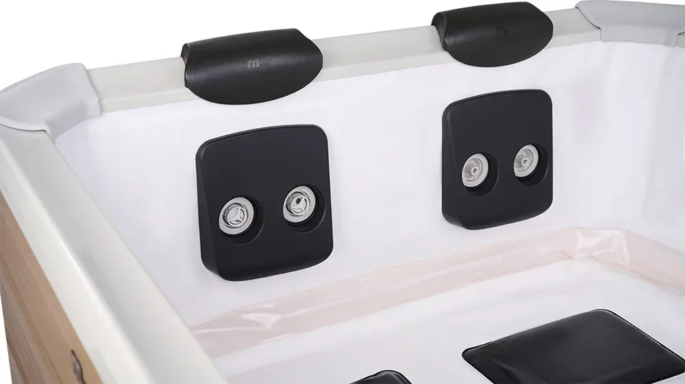 Beyaz jakuzi içinde siyah yastıklı masaj jetleri ve ahşap panel detayları